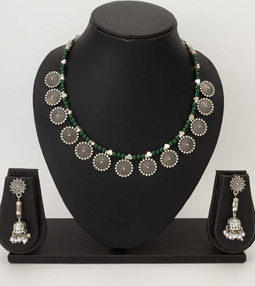 Necklace and earrings set on a black mannequin bust with a plain background
