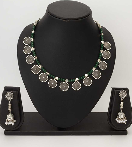 Necklace and earrings set on a black mannequin bust with a plain background